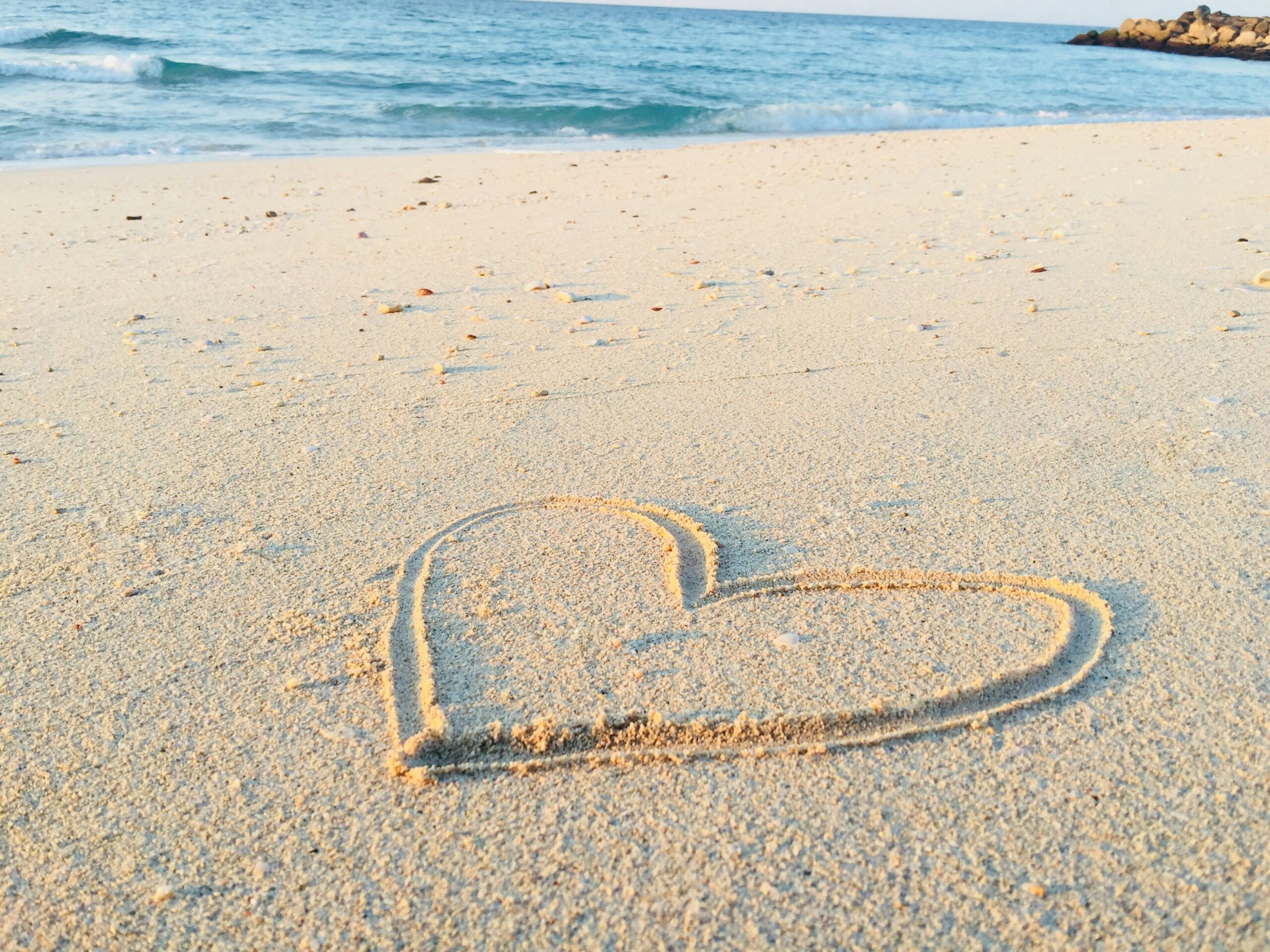 Heart shape drawn on sandy beach